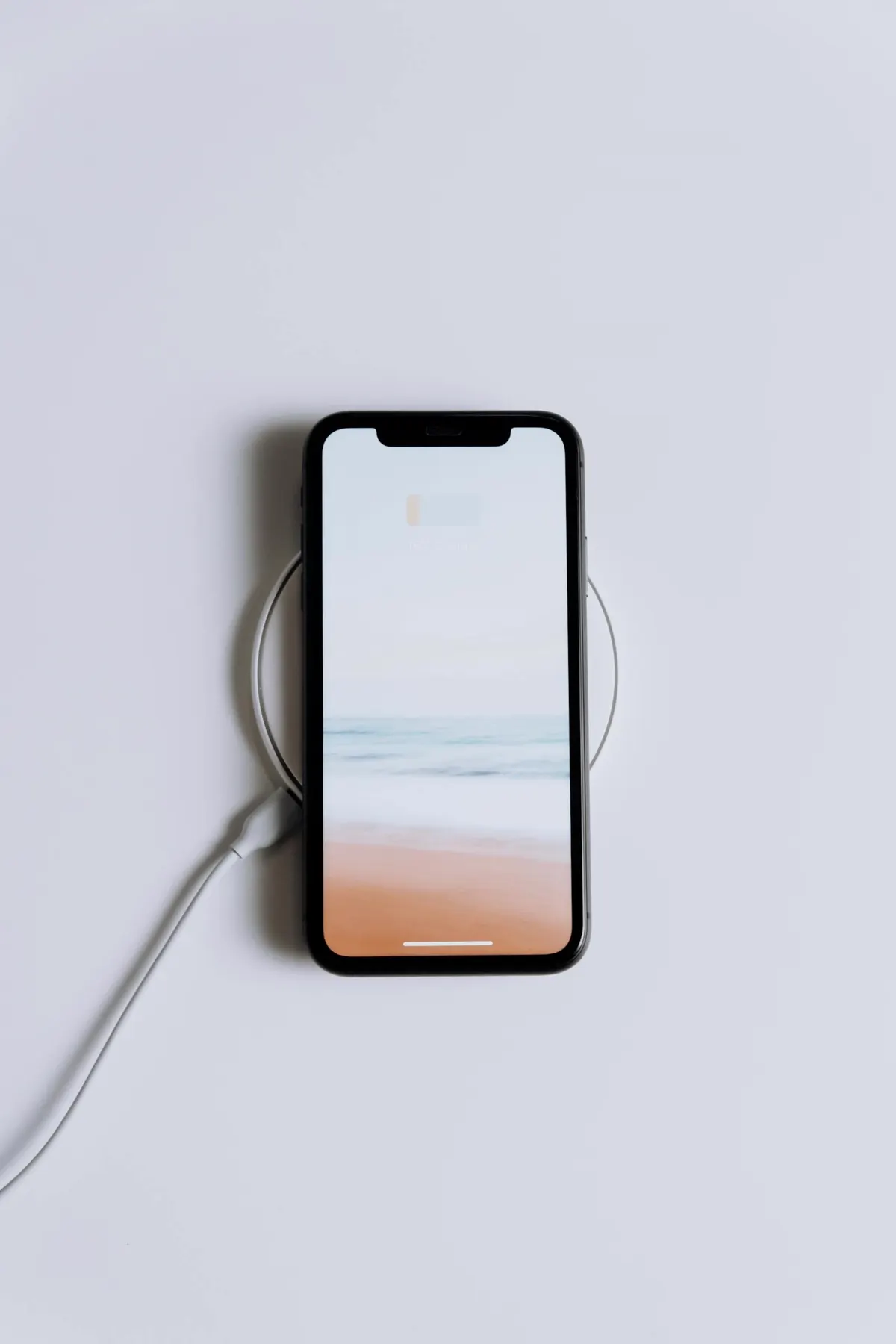 iPhone con cargador certificado MFi sobre mesa